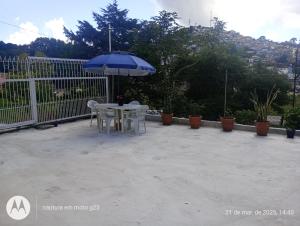 a table and chairs with an umbrella on a patio at Kitnet Privativa no Portal de Campos do Jordão in Campos do Jordão +13 photos