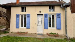 a house with blue shutters and a white door at La maison de la Loire in Nevers