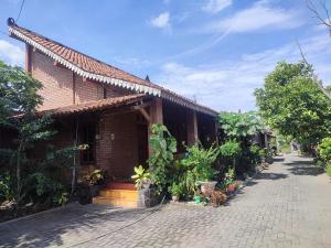 a brick house with a cobblestone street in front of it at Homestay AYODYA in Prambanan
