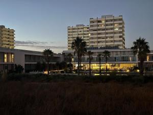 a large building with palm trees in front of it at Estúdio Azul-T0-Torralta-Ocean View by Aura in Alvor