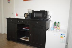 a microwave sitting on top of a cabinet with a refrigerator at b&b da marcello in Sotto il Monte