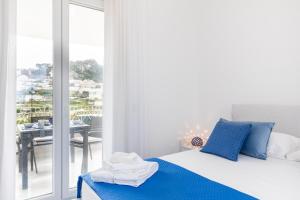 カプリにあるMaison Blue Capriのベッドルーム(青い枕のベッド1台付)、バルコニーが備わります。