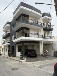 a building with a car parked in a parking lot at Casa dell'Arte in Volos