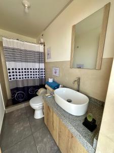 a bathroom with a white sink and a toilet at Habitación con Terraza Vista al Mar in Pimentel +11 photos