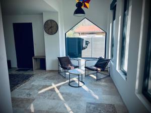 a room with two chairs and a table and a clock at L Orangerie in Maubec
