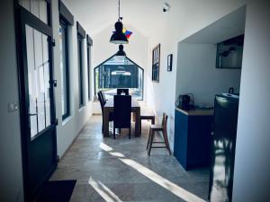 a kitchen and dining room with a table and chairs at L Orangerie in Maubec