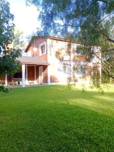 ein Haus mit einer großen Wiese davor in der Unterkunft Shakty "Apart de Montaña" in Los Reartes