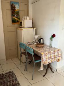 a table with two chairs and a refrigerator at studio sympa in Port-Louis