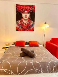 a bedroom with a bed with a painting on the wall at Studio RED MASTER in Saint-Tropez