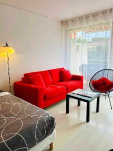 a living room with a red couch and a table at Studio RED MASTER in Saint-Tropez