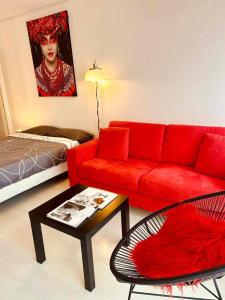 a living room with a red couch and a table at Studio RED MASTER in Saint-Tropez +14 photos