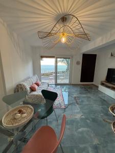 a living room with a chandelier and a table and chairs at Vista mare ! in Cervo
