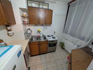a small kitchen with a stove and a sink at Stan Uzice in Užice