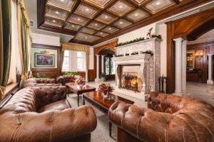 a living room with leather furniture and a fireplace at Festa Winter Palace Hotel in Borovets