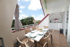 a dining room with a table and chairs on a balcony at Passion Martinique T3 6 pers 72 m2 Pierre&Vacances in Sainte-Luce