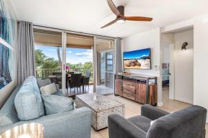 a living room with a couch and a tv at Oceanfront Modern & Elegant Vistas in Kihei