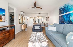 a living room with a blue couch and a table at Oceanfront Modern & Elegant Vistas in Kihei