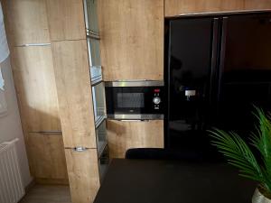 a kitchen with a wooden wall with a microwave at Pied-à-terre de rêve à Marseille - Confort & Style & moderne & équipé & cosy in Marseille +22 photos