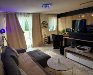 a living room with a couch and a table at Pied-à-terre de rêve à Marseille - Confort & Style & moderne & équipé & cosy in Marseille