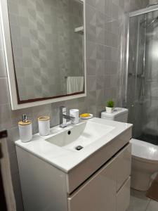 a bathroom with a sink and a toilet and a mirror at T1 Mindelo City Center in Mindelo +15 photos
