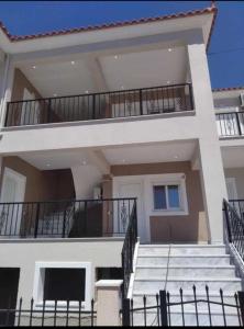 a large white house with stairs in front of it at ANNA DANIIL New Apartment in Arisvi - Kalloni in Kalloni
