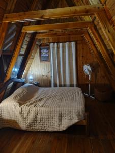 a bedroom with a bed in a wooden cabin at Bungalow San Antonio in San Antonio de Arredondo
