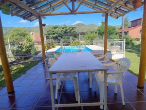 a table and chairs under a wooden pergola at Bungalow San Antonio in San Antonio de Arredondo
