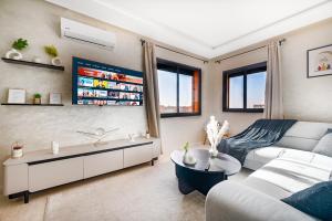 ein Wohnzimmer mit Sofa und Tisch in der Unterkunft Élégant avec Parking - Guéliz Hivernage in Marrakesch