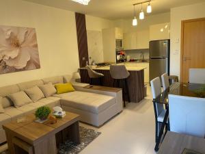 a living room with a couch and a kitchen at Apartment at Marassi in El Alamein