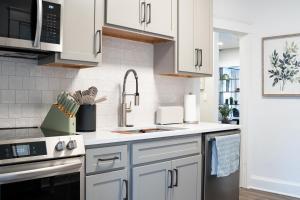 a kitchen with white cabinets and a sink at Little Gem in Millersburg
