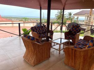 un patio con sedie, un tavolo e un ombrellone di Whispering Hearts Guest House a Botianaw