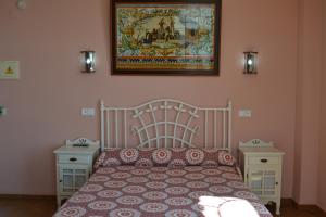 Hotel Restaurante Toruño في إل روثيو: غرفة نوم بسرير وصورة على الحائط