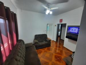 a living room with a couch and a flat screen tv at Casa da Dona Neide in Bodoquena