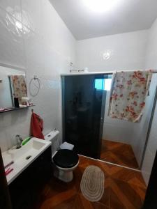 a bathroom with a shower and a toilet and a sink at Casa da Dona Neide in Bodoquena