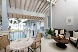 ein Wohnzimmer mit einem Tisch und Stühlen auf dem Balkon in der Unterkunft Selenya Talpe - Boutique Villa in Unawatuna