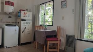 a small kitchen with a table and a refrigerator at Monoambiente in Morón