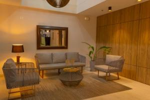 a living room with a couch and chairs and a mirror at VVC Hotel's in Villavicencio