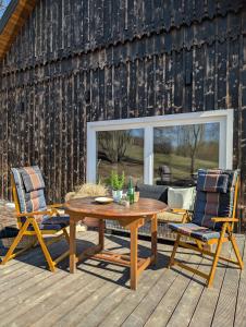a patio with a wooden table and two chairs at Płachtówka in Słupia +100 photos