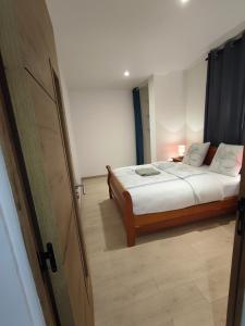 1 dormitorio con 1 cama y puerta abierta en Cœur de la savane, en Bourges