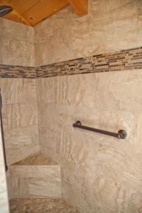 ducha con pared de piedra y toallero en Bryce Canyon Villas, en Cannonville
