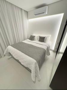 a white bedroom with a large bed with white curtains at Porto Alto Gav Resorts in Porto De Galinhas