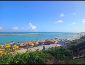 a beach with many umbrellas and people on the beach at Porto Alto Gav Resorts in Porto De Galinhas