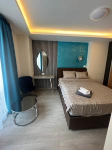 a bedroom with a bed and a mirror and a chair at FREE PARKING City Square Vanilla Apart-Hotel in Skopje +27 photos