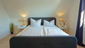 a bedroom with a large bed with two night stands at Huus Günter in Tönning