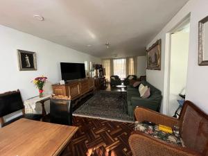 a living room with a couch and a tv at HOMESTAY Yas & Jay in Lima