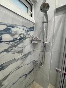 a bathroom with a shower with a marbleiled wall at Ble Property Atlas 6 in Loutraki +22 photos