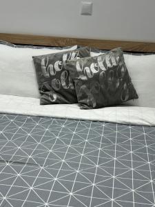 a bed with two black and white pillows on it at Ble Property Atlas 6 in Loutraki