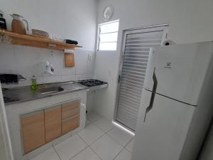 a small kitchen with a refrigerator and a sink at Casa com 2 Camas Queen e 1 King em Quartos Climatizados in Rio de Janeiro +9 photos