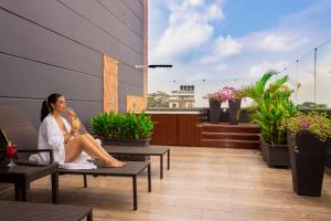 a woman sitting on a chair on a balcony at VVC Hotel's in Villavicencio