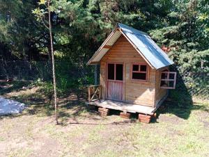 ein kleines Holzhaus mit einem Zinndach in der Unterkunft Quinta Ensenada in Bragado